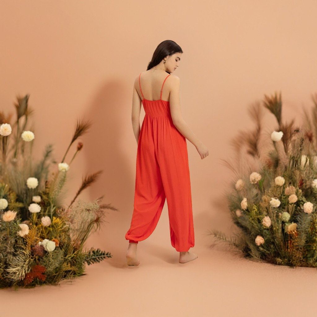 This vibrant orange V-neck jumpsuit is the perfect addition to your summer and spring wardrobe. It's spaghetti straps and lightweight fabric make it ideal for trips and traveling, whether on vacation or just running errands.