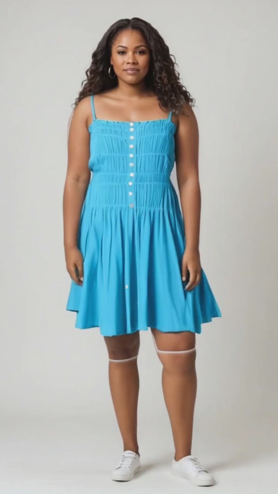 A smocking bodice sleeveless button-down mini dress features a fitted bodice with smocked detailing for a flattering look.